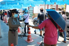 Xịt nước sát khuẩn tay phòng lây nhiễm COVID-19 cho người dân tại một khu chợ ở Bangkok, Thái Lan ngày 9/5/2020. (Nguồn: THX/TTXVN) 