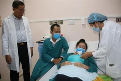 Các bác sỹ thăm khám cháu bé sinh non. (Ảnh: Bùi Giang/TTXVN)