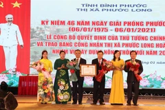 Lãnh đạo tỉnh Bình Phước thừa Ủy quyền trao quyết định của Thủ tướng công nhận thị xã Phước Long hoàn thành nhiệm vụ xây dựng nông thôn mới. (Ảnh: Sỹ Tuyên/TTXVN) 