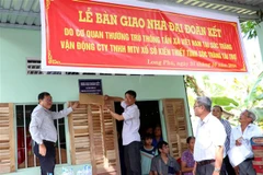 Ông Lâm Long, Giám đốc Công ty Xổ số kiến thiết Sóc Trăng (bên trái) cùng lãnh đạo xã Long Đức bàn giao nhà Đại đoàn kết cho gia đình ông Nguyễn Văn Lên. (Ảnh: Trung Hiếu/TTXVN) 