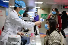 Nhân viên y tế Trung Quốc kiểm tra thân nhiệt một người dân tại bệnh viện ở Phúc Châu, thủ phủ tỉnh miền Đông Nam Phúc Kiến, ngày 31/1/2020. (Nguồn: AFP/TTXVN) 