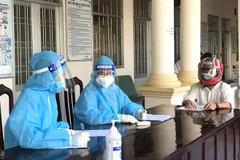 Các nữ nhân viên y tế tư vấn cho người dân trước khi tiêm vaccine phòng COVID-19. (Ảnh: Lê Thúy Hằng/TTXVN) 