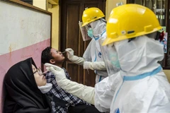 Nhân viên y tế lấy mẫu xét nghiệm COVID-19 cho người dân tại Bandung, Tây Java, Indonesia. (Ảnh: THX/TTXVN) 