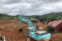 Phương tiện cơ giới khẩn trương đào bới tìm kiếm người bị vùi lấp. (Nguồn: TTXVN phát) 