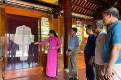Du khách tham quan và nghe thuyết minh về những kỷ vật về Bác Hồ tại Nhà trưng bày bổ sung tại Khu di tích quốc gia đặc biệt Kim Liên. (Ảnh: Bích Huệ/ TTXVN)