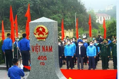 Nghi thức chào cờ tại cột mộc biên giới Cửa khẩu Quốc tế Nậm Cắn (Xã Nậm Cắn, huyện Kỳ Sơn, Nghệ An). (Ảnh: Tá Chuyên/TTXVN) 