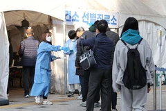 Nhân viên y tế hướng dẫn người dân tại điểm xét nghiệm COVID-19 ở Seoul, Hàn Quốc, ngày 21/11/2022. (Ảnh: Yonhap/TTXVN)