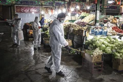 Tình nguyện viên phun thuốc khử trùng tại một khu chợ ở Tehran, Iran ngày 31/3/2020 nhằm ngăn chặn sự lây lan của COVID-19. (Nguồn: THX/TTXVN) 