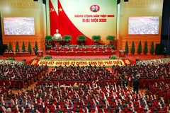 Các đại biểu biểu quyết, thông qua Nghị quyết Đại hội XIII của Đảng. (Ảnh: TTXVN)