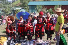 Phụ nữ dân tộc Mông thích thú khi lựa chọn, thử trang phục tại chợ phiên Phìn Hồ. (Ảnh: Xuân Tiến/TTXVN)