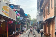 Phố càphê đường tàu là điểm thu hút du khách nhưng tiềm ẩn nguy cơ mất an toàn giao thông đường sất. (Ảnh: Quỳnh Chi/TTXVN) 