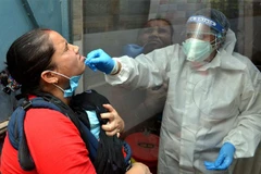 Nhân viên y tế lấy mẫu dịch xét nghiệm COVID-19 cho người dân tại New Delhi, Ấn Độ ngày 19/6/2020. (Nguồn: THX/TTXVN) 