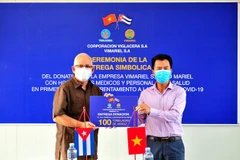 Phó Chủ tịch công ty ViMariel, chi nhánh của Viglacera tại Cuba Nguyễn Ngọc Anh trao tặng tượng trưng 100 tấn gạo cho Thứ trưởng Y tế Cuba Luis Fernando Navarro Martínez. (Ảnh: Lê Hà/TTXVN) 