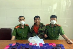 Đối tượng Và Bá Tủa cùng tang vật. (Ảnh: TTXVN phát)