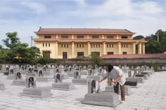Ông Vinh (tóc dài) thắp hương cho các liệt sỹ tại Nghĩa trang Liệt sỹ xã Ninh Hải. (Ảnh: Hải Yến/TTXVN) 