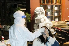 Lực lượng y tế test nhanh kháng nguyên SARS-CoV-2 tất cả người vi phạm. (Ảnh: Tuấn Anh/TTXVN) 