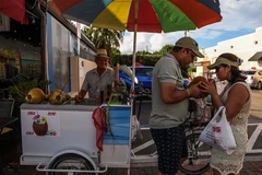 Người dân uống nước giải nhiệt tại Miami, Florida, Mỹ, ngày 26/6/2023. (Ảnh: AFP/TTXVN)