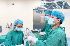Các bác sỹ thực hiện nội soi lấy dị vật 2 bên mũi cho bé gái. (Ảnh: Chanh Đa/TTXVN)