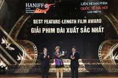 Chủ nhiệm Ủy ban Văn hóa, Giáo dục của Quốc hội Nguyễn Đắc Vinh và Thứ trưởng Bộ Văn hóa-Thể thao và Du lịch Tạ Quang Đông trao giải Phim dài xuất sắc nhất cho bộ phim “Paloma” của Brazil. (Ảnh: Hoàng Hiếu/TTXVN) 