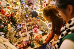 Các bạn trẻ chọn mua các loại đồ trang trí Giáng sinh. (Ảnh: Tuấn Đức/TTXVN)