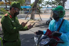 Quét mã QR code trên điện thoại để kiểm tra giấy đi đường của các cá nhân. (Ảnh: Trần Lê Lâm/TTXVN) 