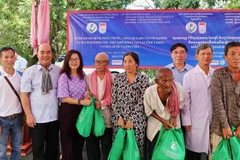 Tổng Lãnh sự Việt Nam tại Sihanoukville Lại Xuân Chiến (bên trái) và đại diện đoàn Việt Nam tặng quà từ thiện cho người dân tại phường Roka Knong, thành phố Daun Keo, tỉnh Takeo. (Ảnh: Quang Anh/TTXVN)