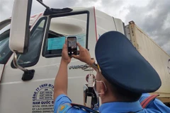 Thanh tra Giao thông tỉnh Kon Tum kiểm tra mã QR Code trên thẻ nhận diện hoạt động luồng xanh của các phương tiện vận tải tại các chốt ra, vào tỉnh. (Ảnh: Dư Toán/TTXVN) 