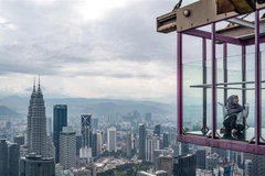Khách du lịch chụp ảnh tại tòa tháp ở thủ đô Kuala Lumpur, Malaysia. (Ảnh: AFP/TTXVN) 