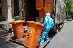 Công nhân vệ sinh thu gom, vận chuyển chất thải tại các cơ sở cách ly COVID-19. (Ảnh: Hồng Giang/TTXVN) 