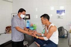 Chủ tịch Ủy ban Nhân dân tỉnh Sóc Trăng Trần Văn Lâu thăm tặng quà Thượng úy Trần Minh Hiếu bị thương khi bắt tội phạm ma túy. (Ảnh: Trung Hiếu/TTXVN) 
