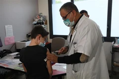 Nhân viên y tế tiêm vaccine phòng COVID-19 cho trẻ em tại Antibes, Pháp, ngày 23/12/2021. (Ảnh: THX/TTXVN) 