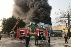 Lực lượng Cảnh sát phòng cháy chữa cháy làm nhiệm vụ tại hiện trường vụ cháy. (Ảnh: Tiến Vĩnh/TTXVN)