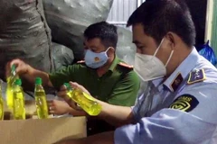 Tổ liên ngành chống buôn lậu tỉnh An Giang phát hiện hàng ngàn chai nước rửa chén nhái nhãn hiệu nổi tiếng tại cơ sở kinh doanh Lâm Thị Y. (Ảnh: TTXVN phát) 