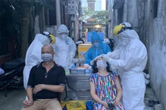 Lực lượng y tế lấy mẫu xét nghiệm những người liên quan đến các ca dương tính ở phường Việt Hưng (quận Long Biên, Hà Nội). (Ảnh: Văn Cảnh/TTXVN) 