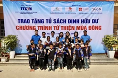 Đoàn thanh niên TTXVN trao tặng "Tủ sách Đinh Hữu Dư" tại Trường phổ thông dân tộc bán trú Tiểu học và Trung học cơ sở Chế Tạo, huyện Mù Căng Chải, Yên Bái. (Ảnh:Minh Công/TTXVN) 