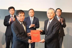 Phó chủ tịch thường trực Ủy ban Nhân dân tỉnh Quảng Bình Đoàn Ngọc Lâm trao cho ông Hitoshi Honna - Chủ tịch kiêm Tổng Giám đốc Công ty cổ phần Erex Co.,Ltd., Nhật Bản biên bản ghi nhớ về việc thực hiện dự án Nhà máy Điện sinh khối Quảng Bình. (Ảnh: Phạm 