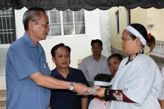 Ông Lữ Văn Hùng, Bí thư Tỉnh ủy Bạc Liêu, tặng quà, động viên vợ ông Châu Khêl. (Ảnh: Huỳnh Sử/TTXVN) 