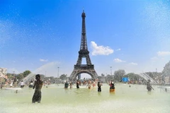 Người dân tránh nóng bên vòi phun nước tại Paris, Pháp, ngày 25/7/2019. (Nguồn: THX/TTXVN) 
