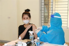 Tiêm vaccine phòng COVID-19 cho người dân. (Ảnh: Bích Huệ/TTXVN) 