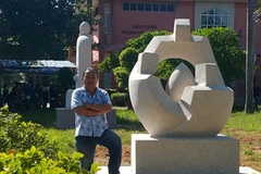 Nhà điêu khắc Vương Hữu Tư bên tác phẩm 'Đồng đội' của ông tại Bảo tàng Thành cổ Quảng Trị. (Nguồn: Báo Thanh niên) 