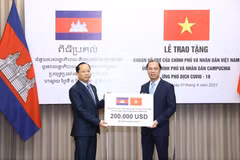 Thứ trưởng Ngoại giao Nguyễn Quốc Dũng trao tượng trưng cho Đại sứ Campuchia tại Việt Nam Chay Navuth khoản hỗ trợ 200.000 USD của Chính phủ và nhân dân Việt Nam. (Nguồn: Bộ Ngoại giao) 