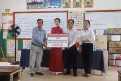 Phu nhân Bộ trưởng Ngoại giao Việt Nam Vũ Thị Bích Ngọc (áo đỏ) trao tặng quá cho Hiệu trưởng Trường Tiểu học Hữu nghị Khmer Việt Nam tại tỉnh Prey Veng. (Ảnh: Trang Nhung/TTXVN) 