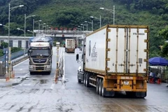 Các xe container qua cửa khẩu quốc tế đường bộ số II Kim Thành. (Ảnh: Quốc Khánh/TTXVN) 