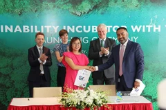 Đại diện Ngân hàng Standard Chartered ký kết hợp tác hỗ trợ Dear Our Community thực hiện Chương trình Ươm mầm Phát triển Bền vững. (Ảnh: Hứa Chung/TTXVN)