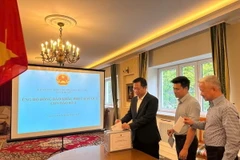 Cán bộ, nhân viên Đại sứ quán Việt Nam tại Ba Lan quyên góp ủng hộ đồng bào khắc phục hậu quả của cơn bão số 3. (Ảnh: TTXVN phát)