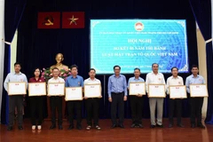 Ông Trần Hữu Phước, Phó Chủ tịch Ủy ban Mặt trận Tổ quốc Việt Nam Thành phố Hồ Chí Minh, tặng Bằng khen cho đại diện tập thể có thành tích trong thực hiện Luật Mặt trận Tổ quốc Việt Nam. (Ảnh: Xuân Khu/TTXVN) 