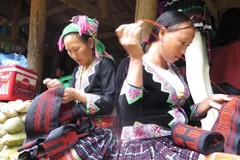 Người dân bản Sin Suối Hồ, Lai Châu thêu những tấm thổ cẩm để bán cho du khách. (Ảnh: Việt Hoàng/TTXVN) 