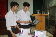 Học sinh Đào Thái Bình Dương và Nguyễn Quang Huy hoàn thiện sáng kiến. (Ảnh: Thùy Dung/TTXVN) 