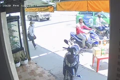 Nam thanh niên (áo đỏ) giật tập vé số rồi bỏ chạy. 