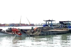 Hai phương tiện vận chuyển cát không rõ nguồn gốc bị bắt giữ. (Ảnh : TTXVN phát) 